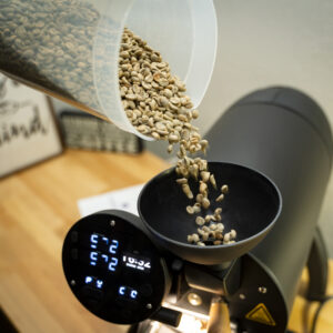 Green Colombian coffee beans pouring into an Aillio Bullet roaster